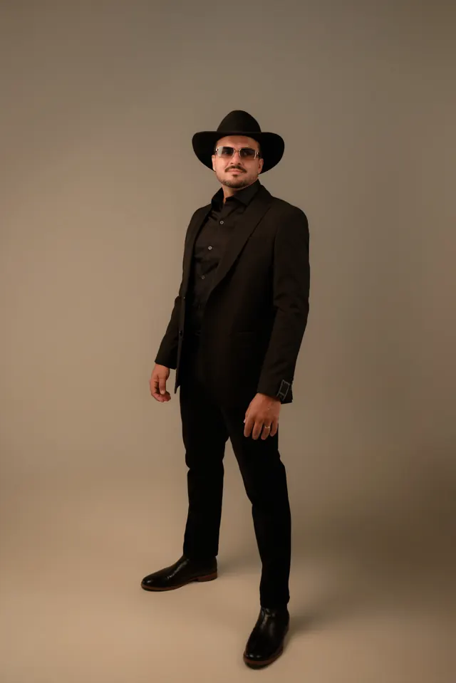 Fernando Marques em pé, de terno e chapéu pretos